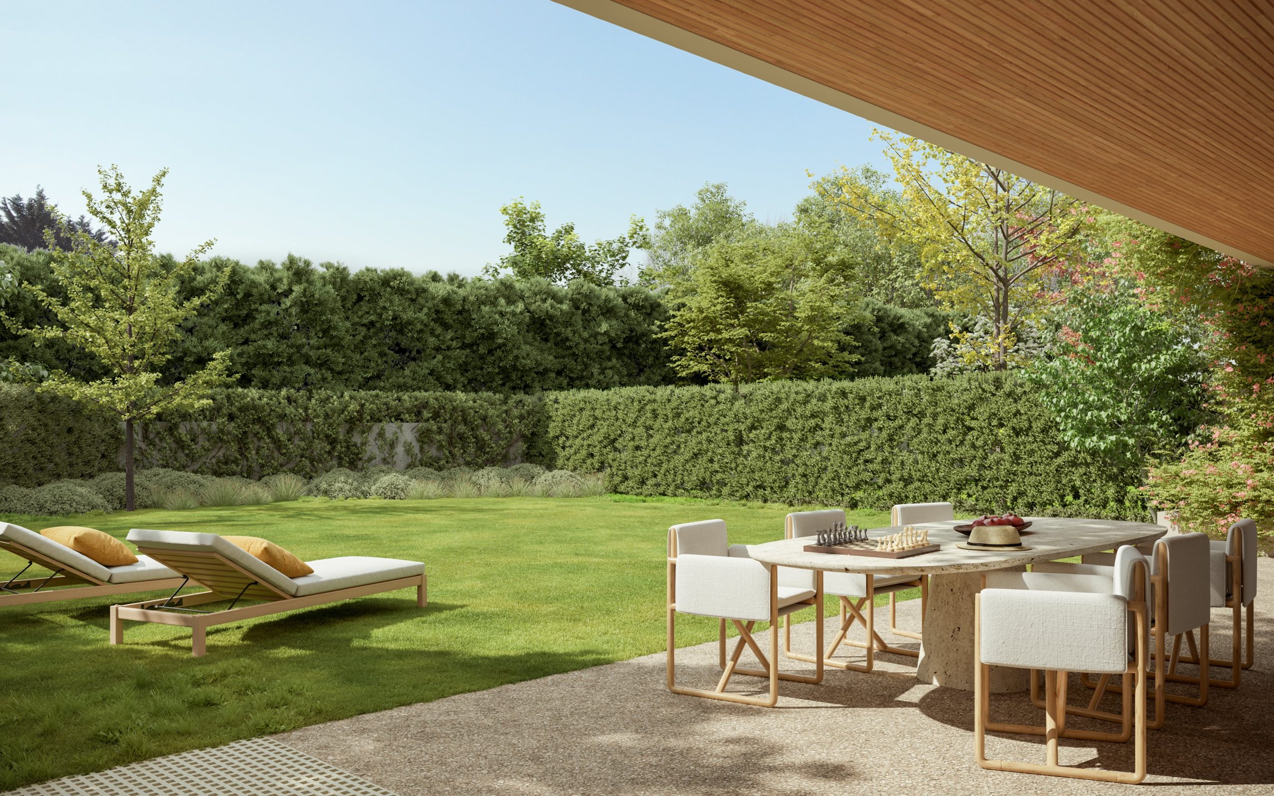 Terraço e jardim do empreendimento Foliage Fercopor na Foz do Porto, com mesa de refeição, espreguiçadeiras e natureza envolvente para relaxar.